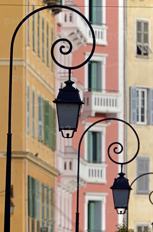 The silhouettes of street lamps in Ajaccio  and the facades of houses in the background. Ajaccio is the capital of the mediterranean island of Corsica