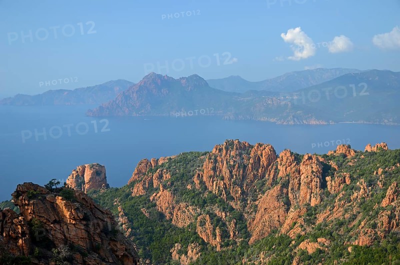 The typical bizarre red rocks of the Calanche of Piana and the mediterranean sea at the Gulf of Porto in the background. The Calanche of Piana is in the western part of the island Corsica