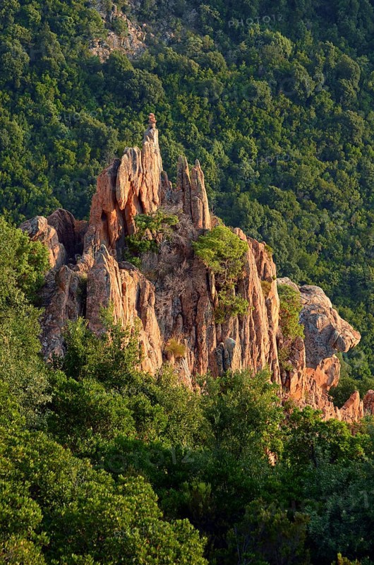 The typical bizarre red rocks of the Calanche of Pianasurrounded by green scrub. The Calanche of Piana is in the western part of the island Corsica