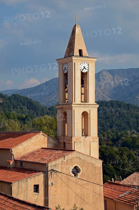 The church of the small village Evisa illuminated by warm evening light surrounded by mountains. Evisa is in the department Corse-du-Sud