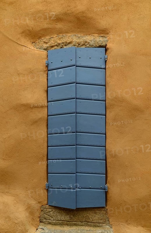 Yellow house wall and a closed blue door