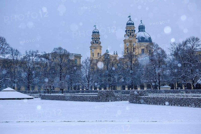 Hofgarten garden with Theatinerkirche St. Cajetan church in driving snow