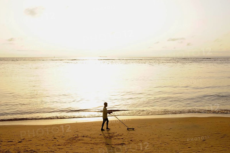 Boy playing on Kribi beach with a homemade toy