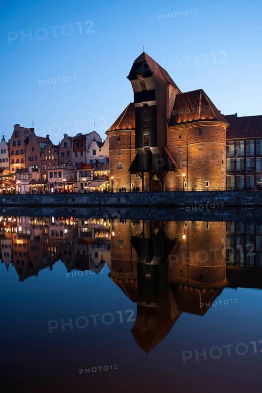 Crane Gate or Brama Zuraw in the historic row of houses at dusk