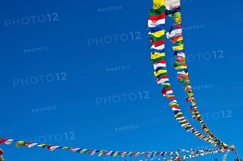 Buddhist prayer flags in front of blue sky above Namche Bazar (3.440 m)