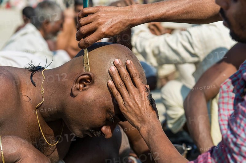 Pilgrim having his head shaved during Kumbha Mela
