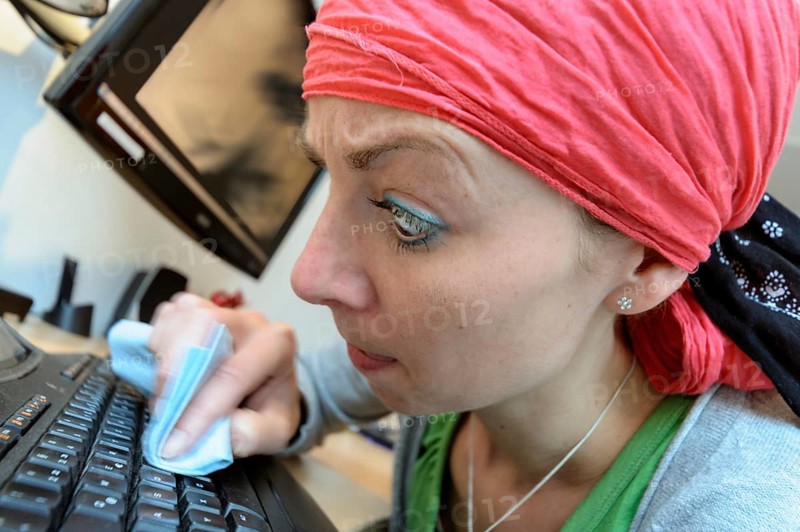 Cleaning lady cleaning a computer keyboard