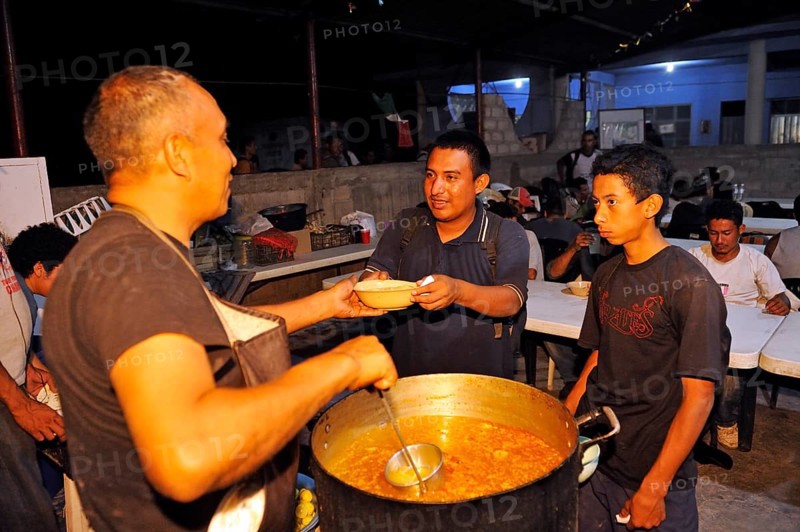 Migrants from Latin America crossing Mexico on their way to the U.S. receiving food in a Christian shelter