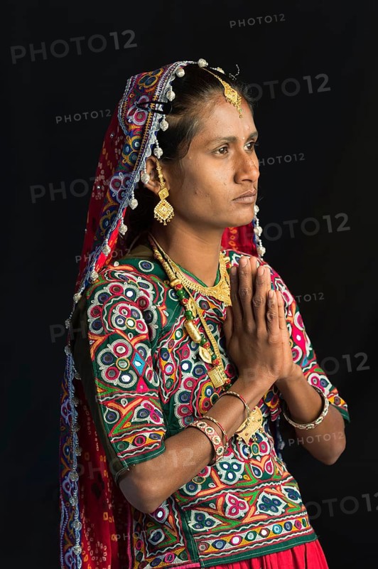 Ahir woman in traditional colorful clothes praying