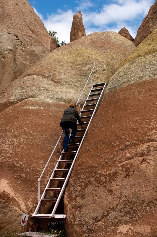 Visitor using a ladder on a hike through the tufa