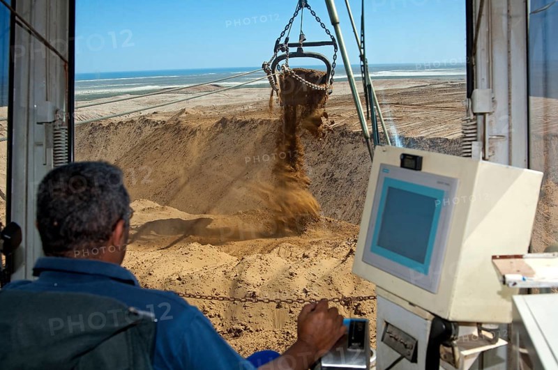 Excavator operator in the cab of a dragline excavator working in the diamond mine of De Beers Namaqualand Mines