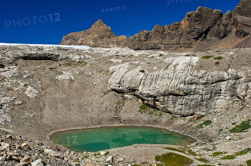 Lake of green meltwater in a doline or sinkhole in the end moraine of Tsanfleuron Glacier at Sanetsch Pass