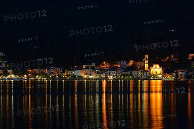 Village of Porto Ceresio with the Parish Church of Chiesa Sancto Ambrosio on Lake Lugano or Lago di Lugano at night