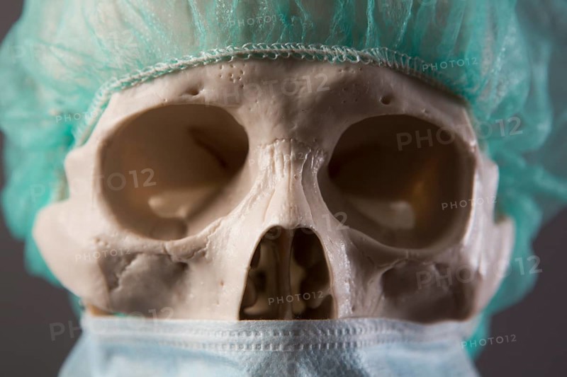 Skeleton dressed as a doctor with surgical mask and cap