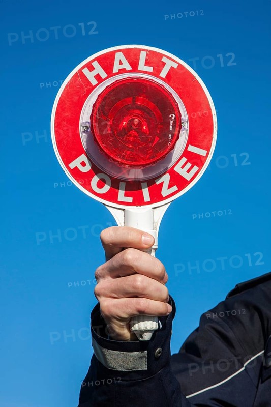 Policeman holding a police signalling disc