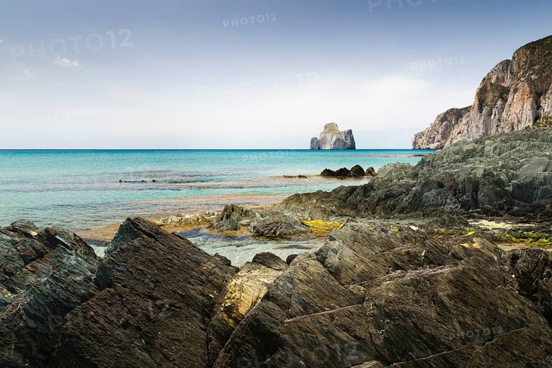 Spiaggia di Masua bay with the Pan di Zuccherof ??rock island in the sea