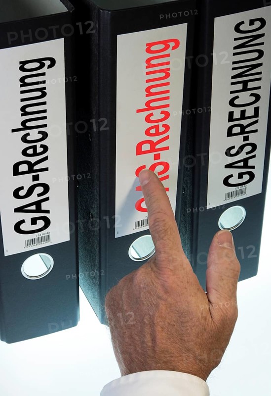 Hand pointing to a ring binder labeled Gasrechnung