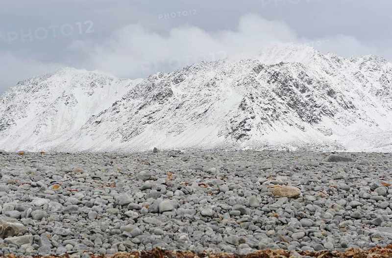 Gravel field in front of a snow-covered summit ridge