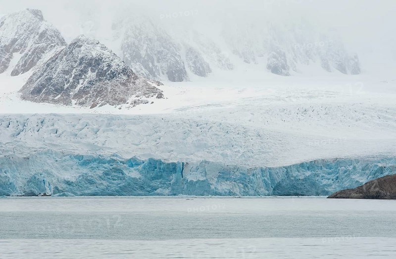 Glacial ice in the rocks surrounding a fjord