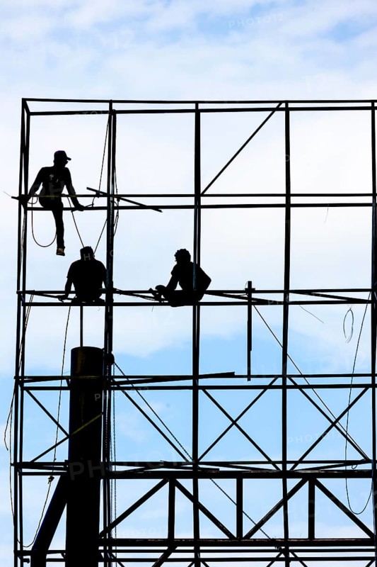 Unsecured workers assembling a scaffold