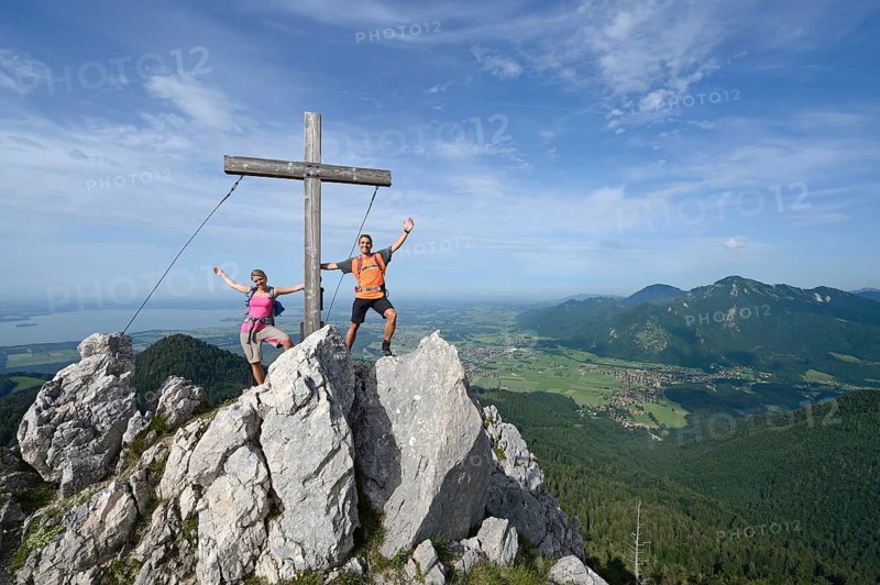 Hikers standing next to the cross on the summit of Friedenrath mountain