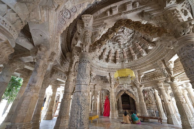 Women sitting in the Interior hall with ornate pillars and ceilings in the marble temple
