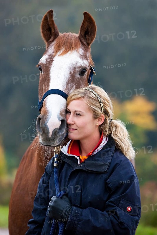 Young woman cuddling a Austrian Warmblood