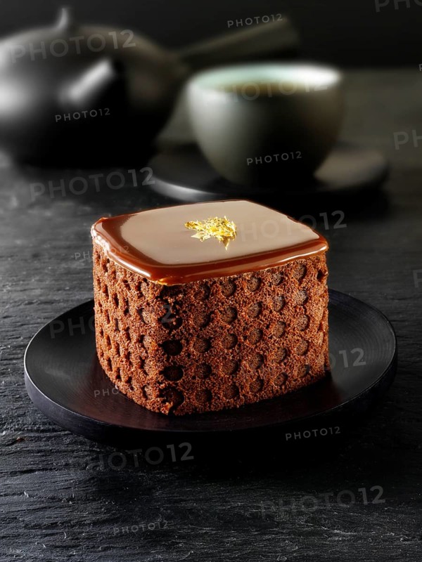 Cake with a sponge case and chocolate filling in a black Japanese tea setting