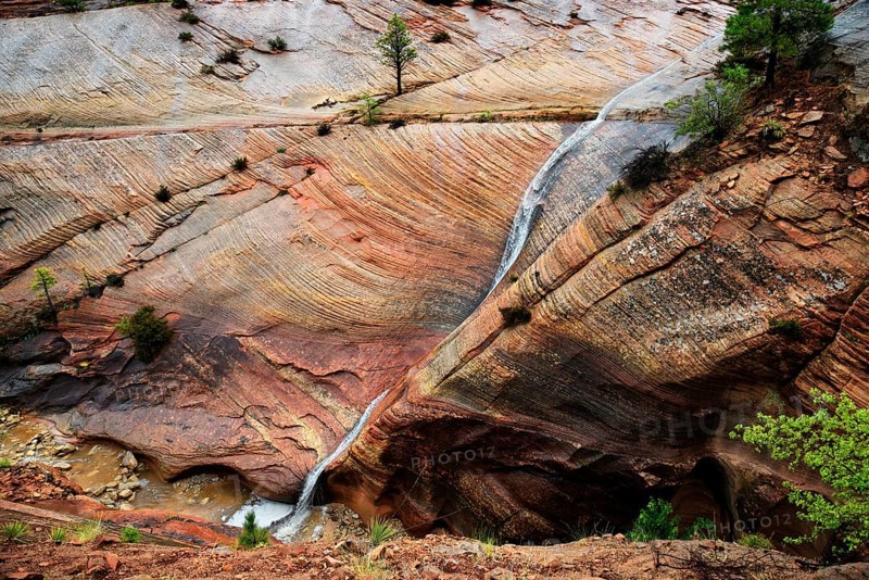 Water draining off over red Navajo sandstone rocks after a rainstorm near Canyon Overlook