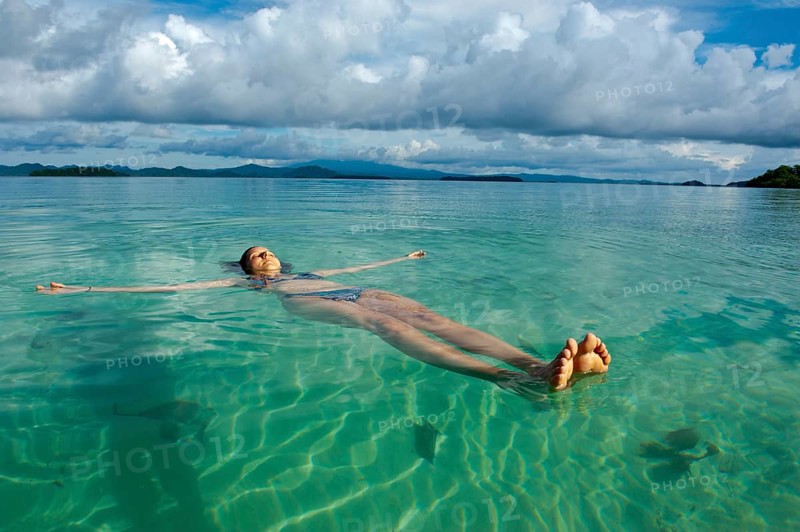 Tourist floating in the clear water of the Marovo Lagoon