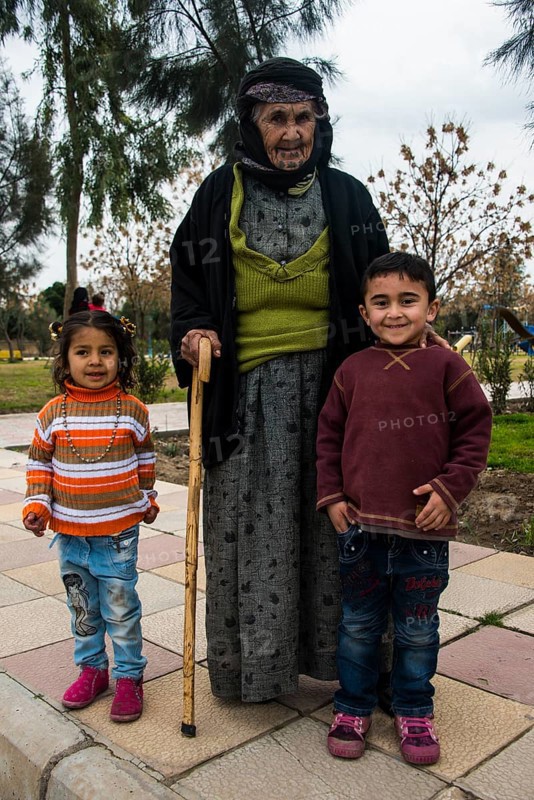 Syrian Orthodox Kurdish woman with tattoos on her face and her grandchildren