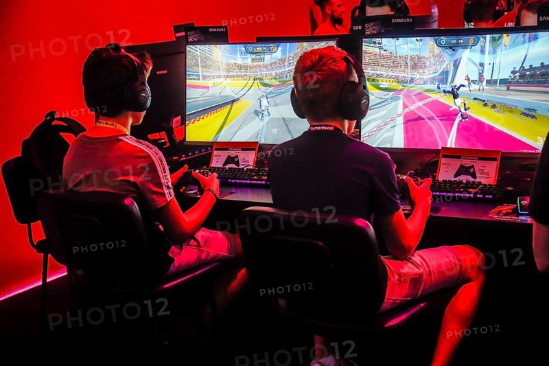 Boys playing computer games in front of screens