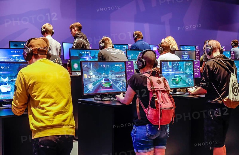 Young visitors at Need for Speed car racing game in front of screens