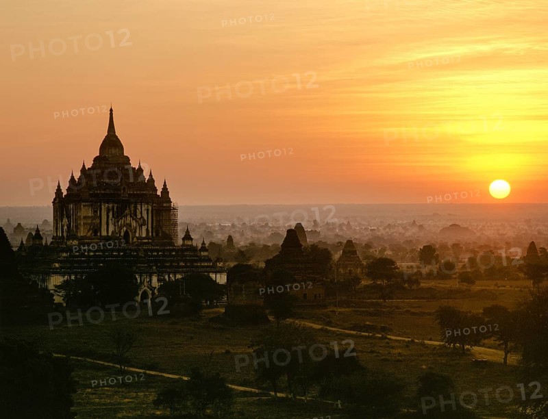 Field with ruins of Buddhist pagodas with Thatbyinnyu Temple at sunset