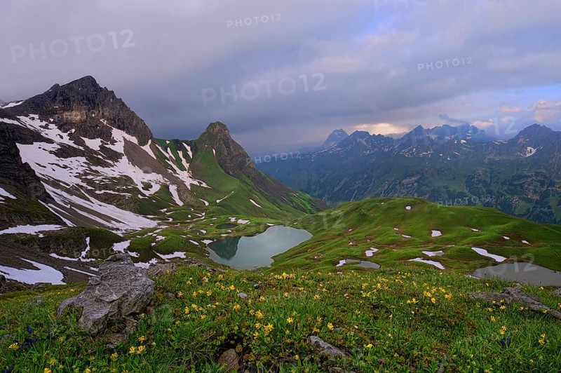 Rappensee Lake with an alpine meadow and a panoramic view of the mountains