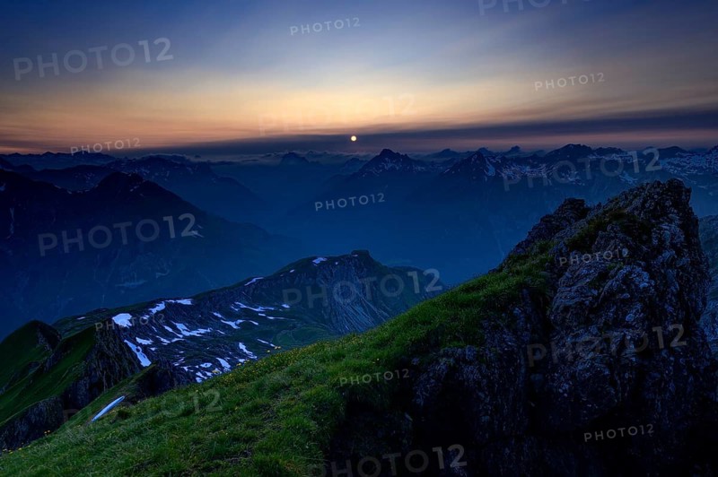 Mountain pasture at sunset with a panoramic view of the mountains
