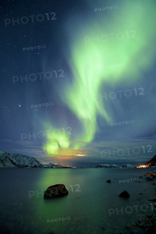 Northern Lights over fjord with winter landscape