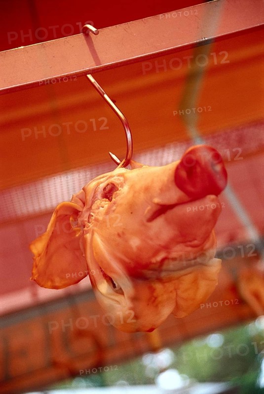 Pig's head in a display window on a hook
