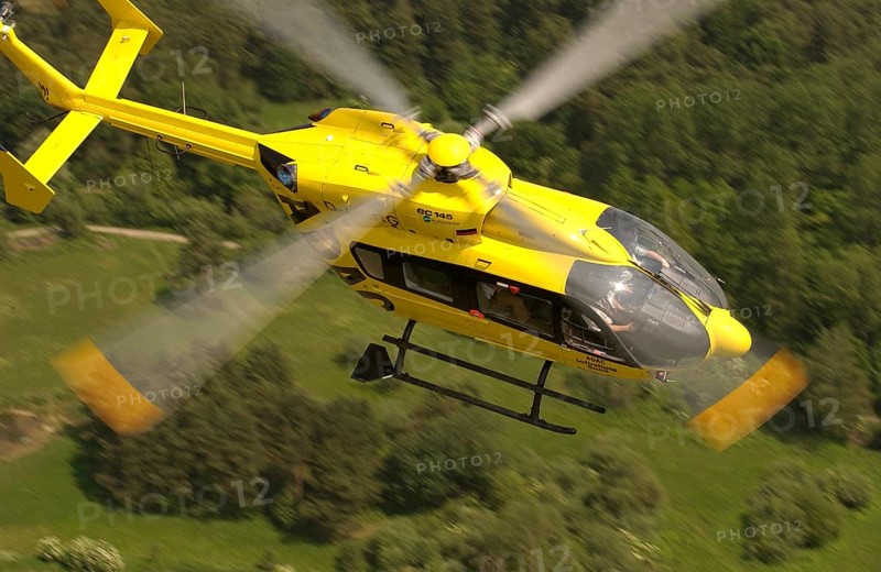 ADAC helicopter flying over a forest