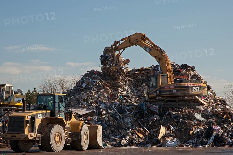 Workers pile debris from Hurricane Sandy in a parking lot next to the beach on Staten Island