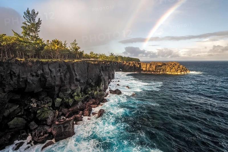 Rainbow and waves of a story sea at Cap Mechant