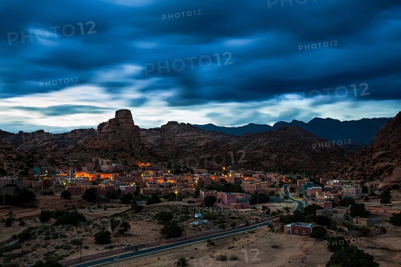 Small village of Aguard Oudad with brightly painted houses in front of the rock Chapeau Napoleon