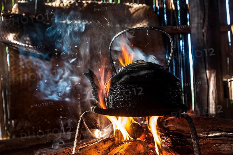 Kettle over an open fire in a kitchen made of bamboo
