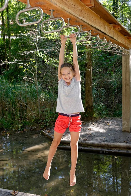 Girl swinging above water