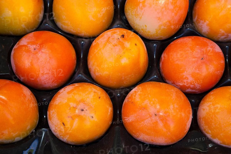 Persimmons (Diospyros kaki) in a fruit crate