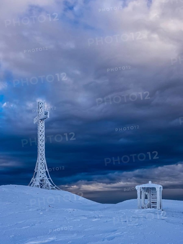 Summit cross and a small hut covered with hoarfrost