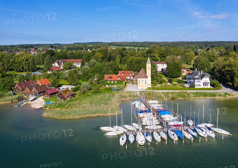 Boat landing stage in the Lake Ammer and church St. Alban