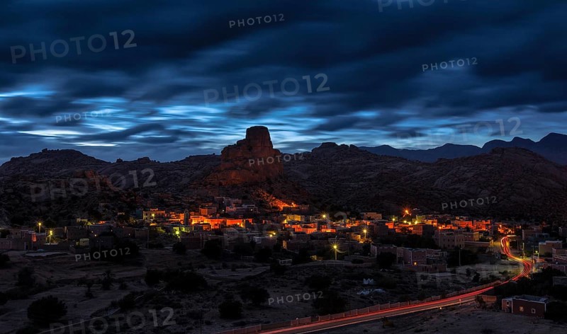 Small village of Aguard Oudad with brightly painted houses in front of the rock Chapeau Napoleon