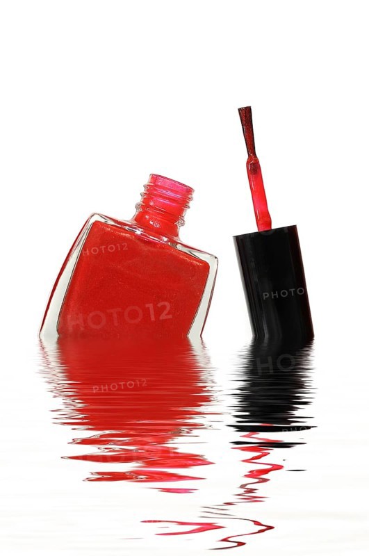 Red nail polish bottle with brush in water