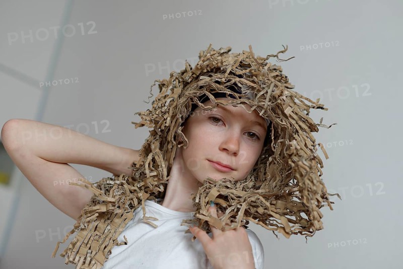 Girl wearing a wig made from cardboard packaging